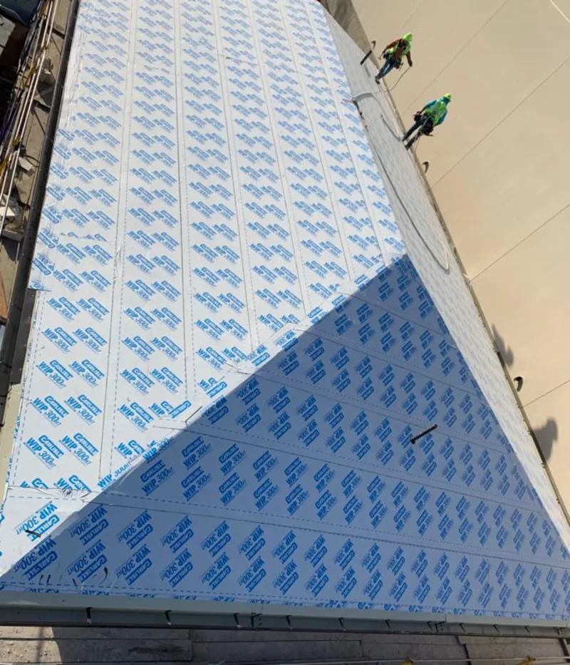 Professional roofers installing underlayment on a metal roof in Kalamazoo